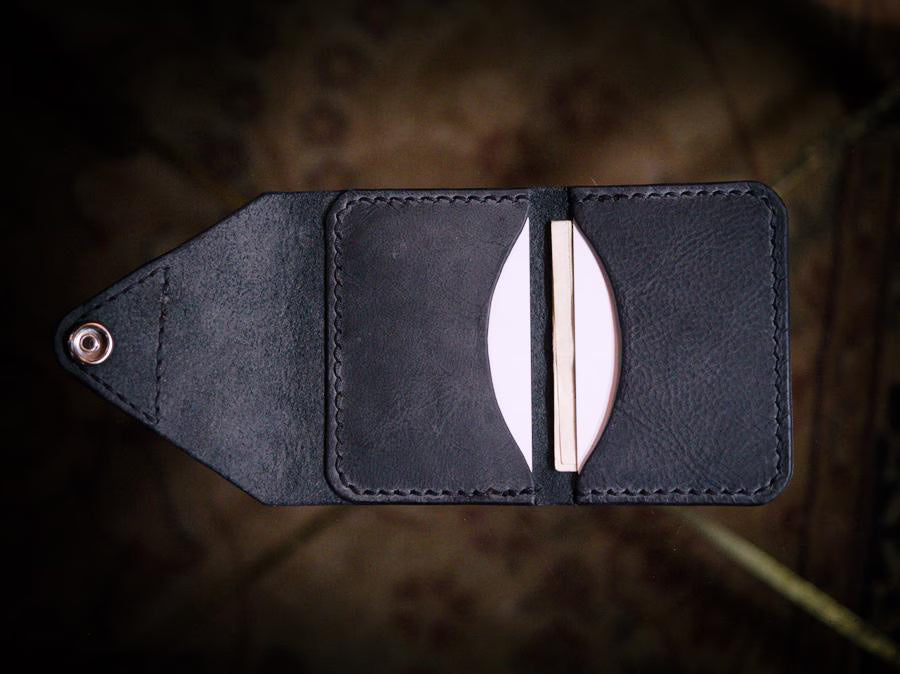 Handmade black chrome-tanned leather letter fold snap wallet, open showing two card pockets Black leather snap wallet with white saddle stitching, handmade in America Handmade letter fold snap wallet closed, black chrome-tanned leather with snap rivet closure