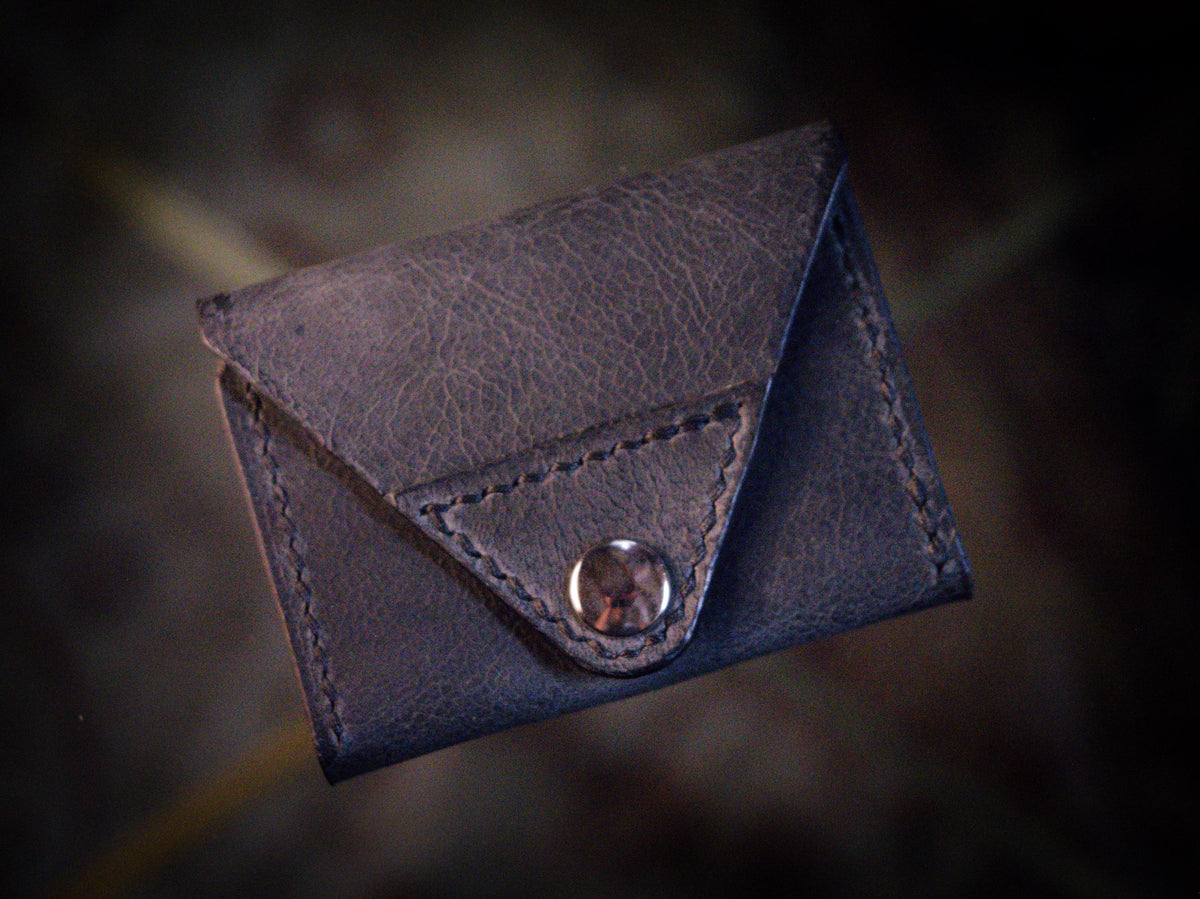 Handmade black chrome-tanned leather letter fold snap wallet, open showing two card pockets Black leather snap wallet with white saddle stitching, handmade in America Handmade letter fold snap wallet closed, black chrome-tanned leather with snap rivet closure
